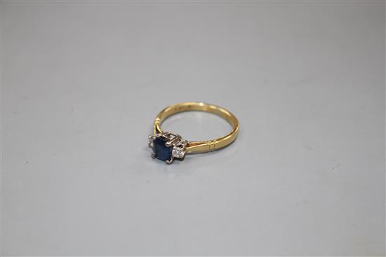 An 18ct, sapphire and diamond three stone ring, size N, gross weight 2.6 grams.